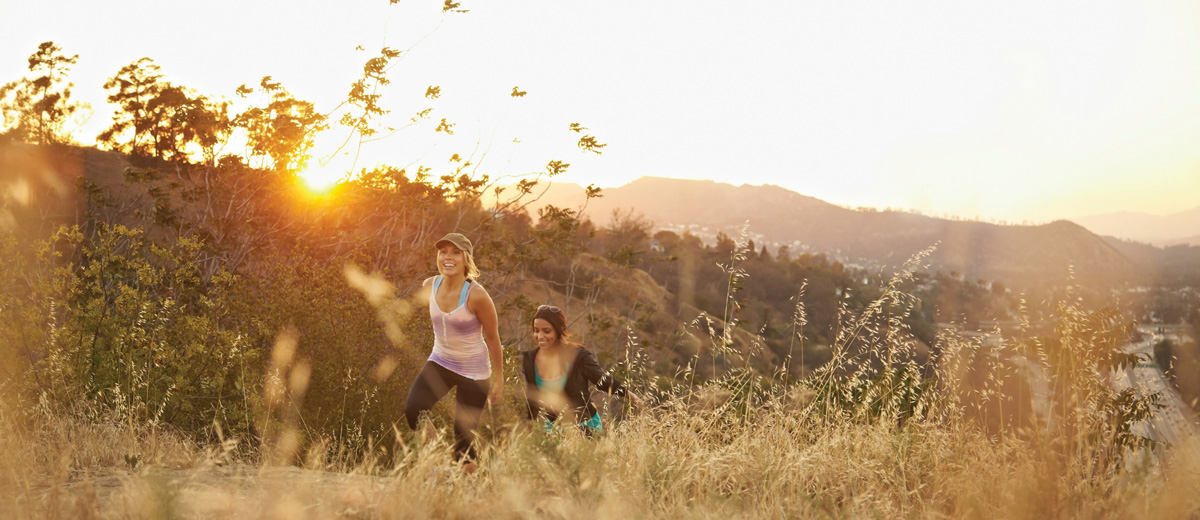 Two young woman hiking at sunset